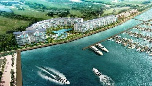 Marina Collection, artist’s impression: an aerial view of the development curving along the marina, with boats in the channel and the golf course behind